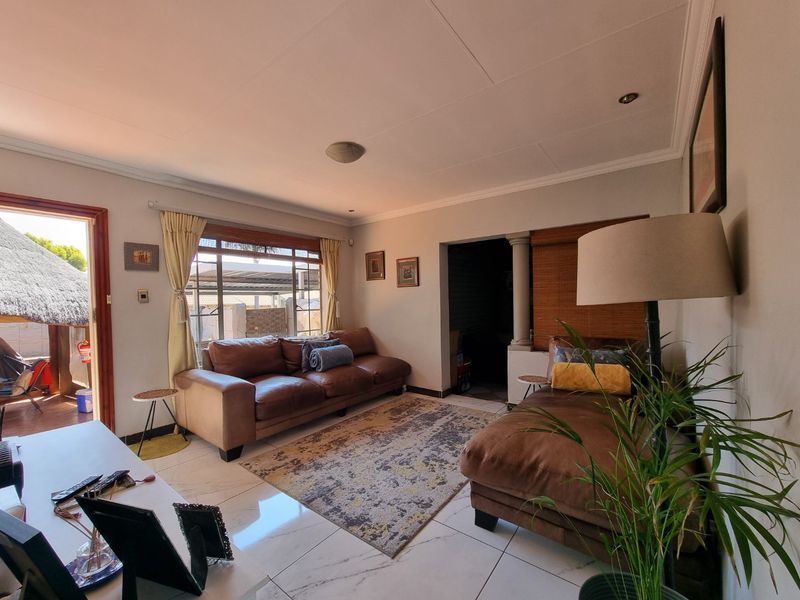 A comfortable living room featuring tiled flooring, recessed lighting, and direct access to an outdoor patio area.