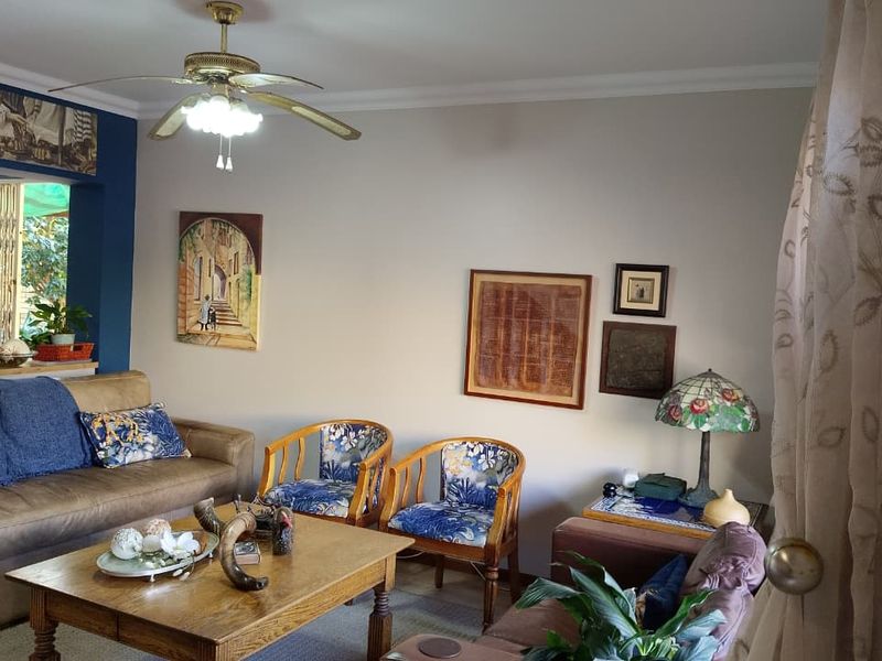 A living room area featuring a ceiling fan and neutral wall finishes, providing a comfortable space for relaxation.