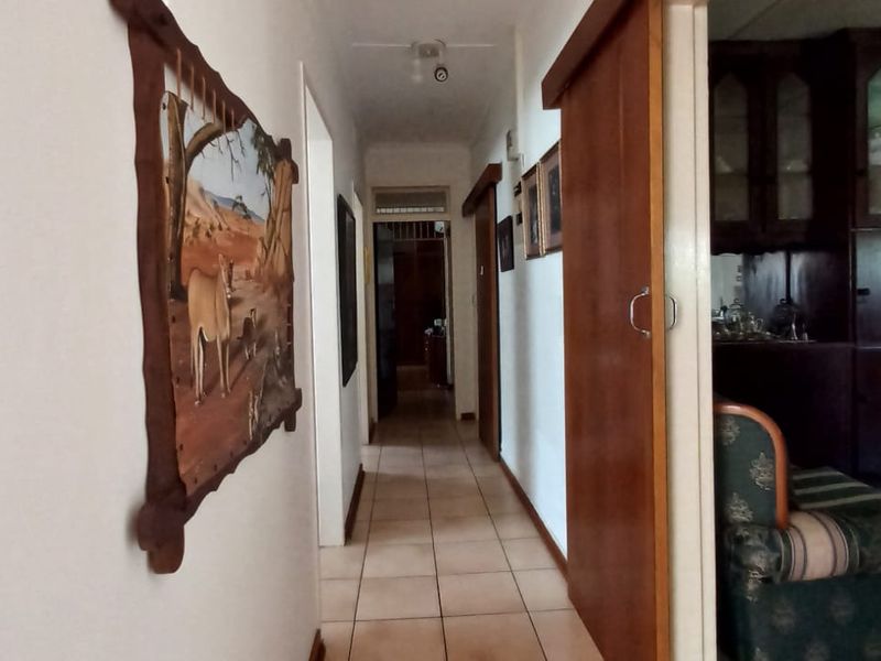 A functional hallway featuring tiled flooring and a sliding wooden door providing access to adjacent living spaces.
