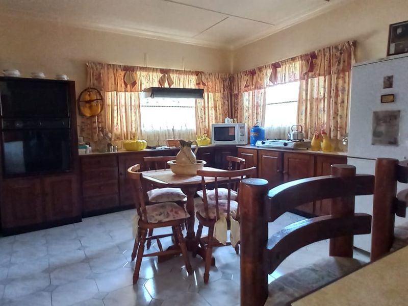 A traditional kitchen featuring wooden cabinetry, tiled flooring, and a built-in oven, offering a functional layout with ample storage space.
