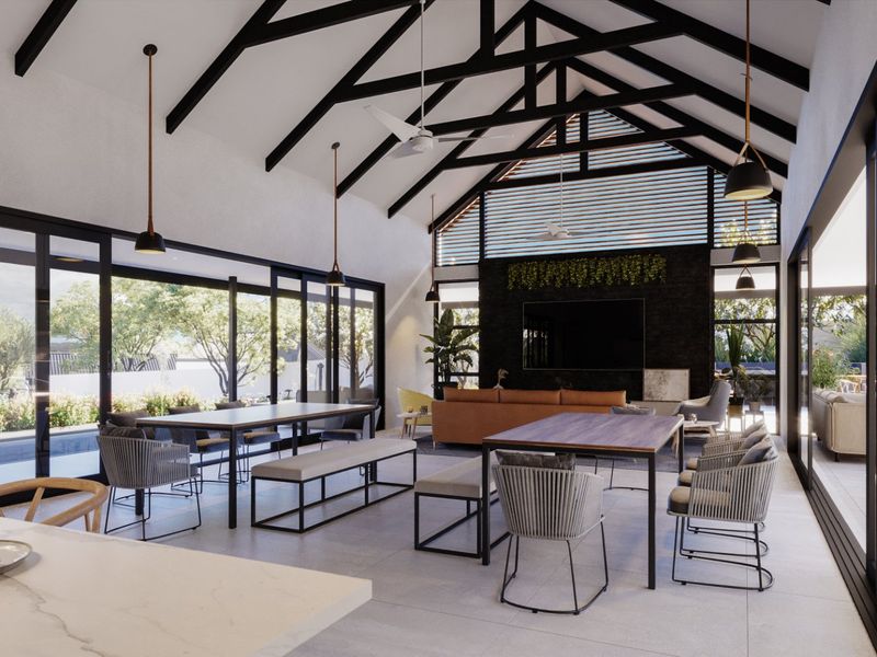 Spacious open-plan living area featuring a dramatic vaulted ceiling with exposed trusses, stone feature wall, and expansive sliding glass doors opening to the outdoors.