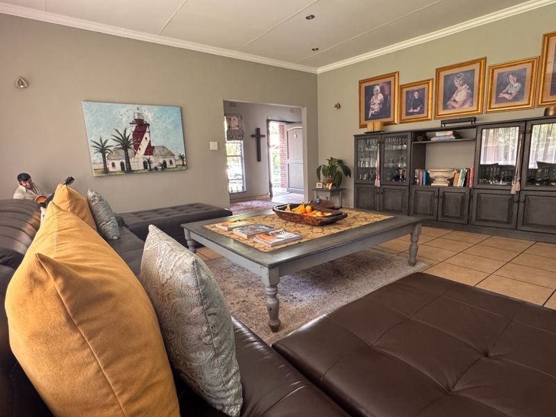 Spacious living room featuring tiled flooring, recessed ceiling lighting, and built-in display cabinetry, offering a comfortable and functional family living space.