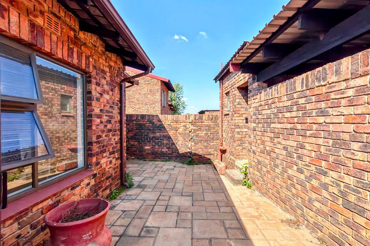A private rear courtyard featuring face brick walls and paved flooring, providing a low-maintenance outdoor space.