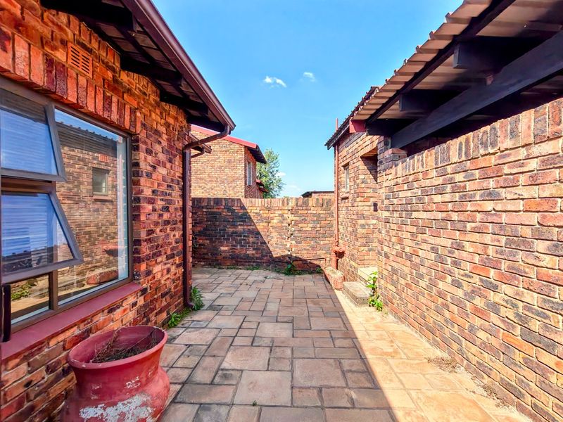 A private rear courtyard featuring face brick walls and paved flooring, providing a low-maintenance outdoor space.