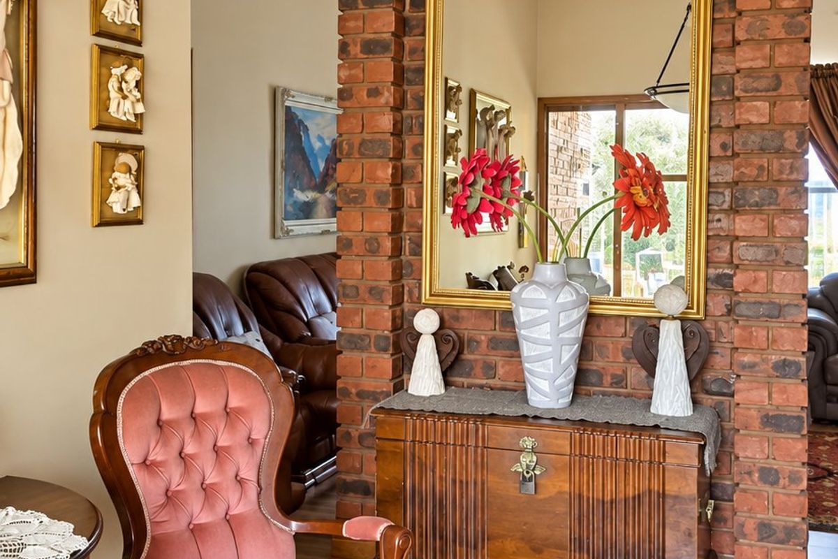 A living area featuring a prominent exposed brick feature wall, laminate flooring, and a decorative pendant light fixture.