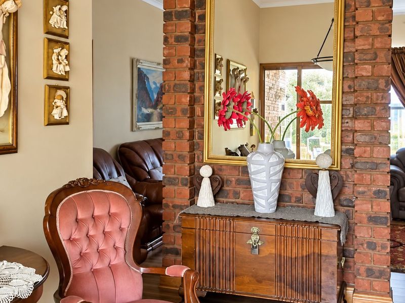 A living area featuring a prominent exposed brick feature wall, laminate flooring, and a decorative pendant light fixture.