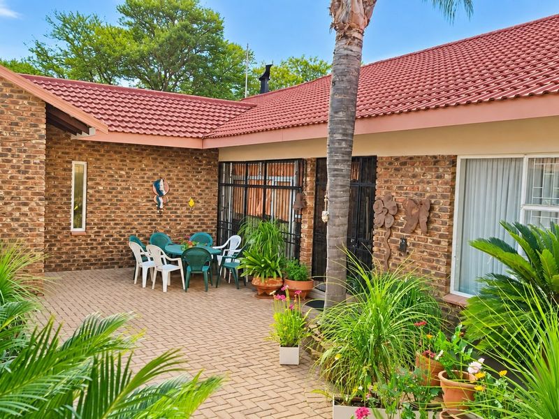 A paved outdoor patio area featuring facebrick walls, secure access points, and a tiled roof, providing a functional space for outdoor relaxation.
