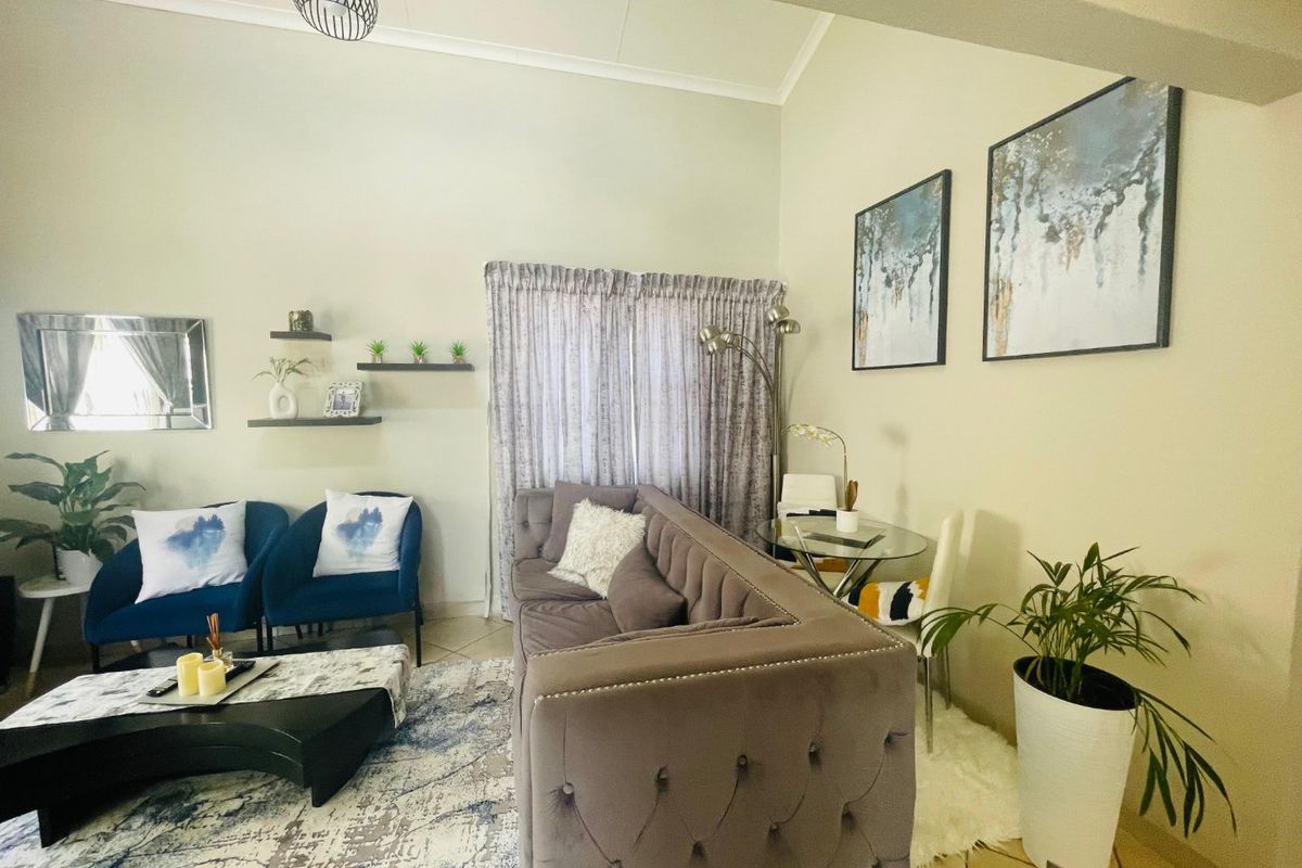 A spacious living room featuring high vaulted ceilings and neutral tiled flooring, offering a bright and comfortable atmosphere for relaxation.