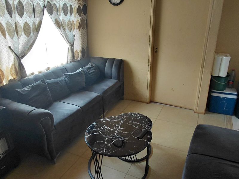 A living room area featuring tiled flooring and neutral wall finishes, providing a functional space for relaxation.