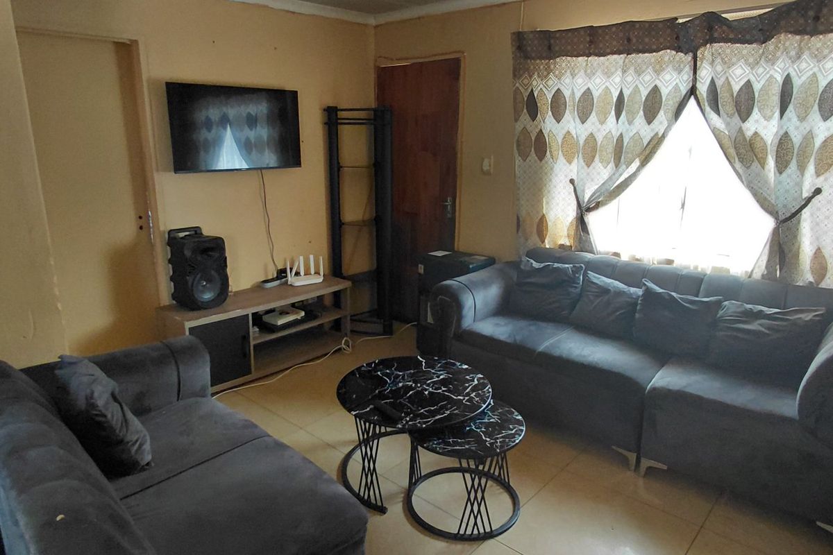 A compact living room featuring tiled flooring and neutral wall finishes, providing a functional space for relaxation.