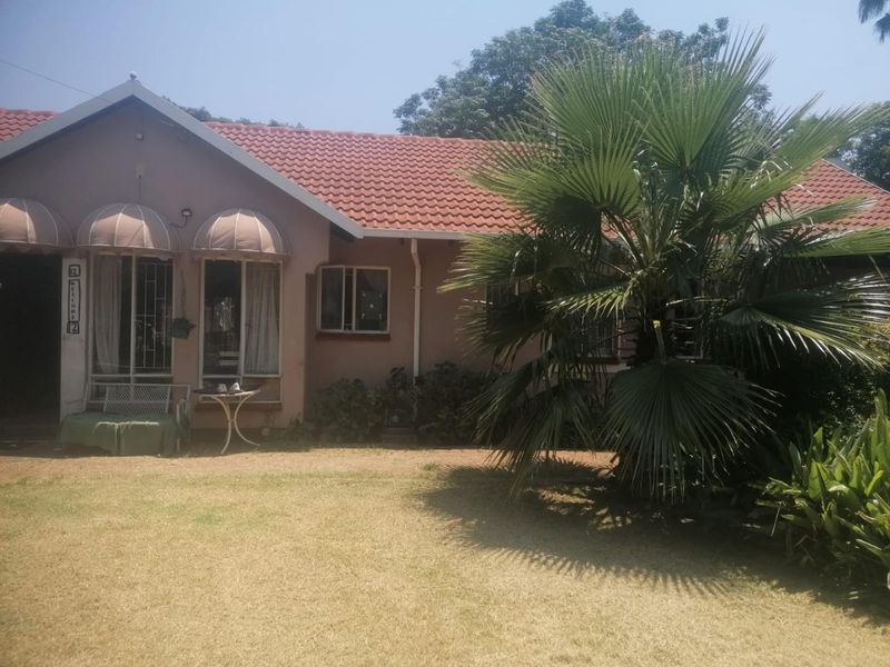 Front elevation of a single-story house featuring a tiled roof, security bars on windows, and decorative awnings over the entrance area.