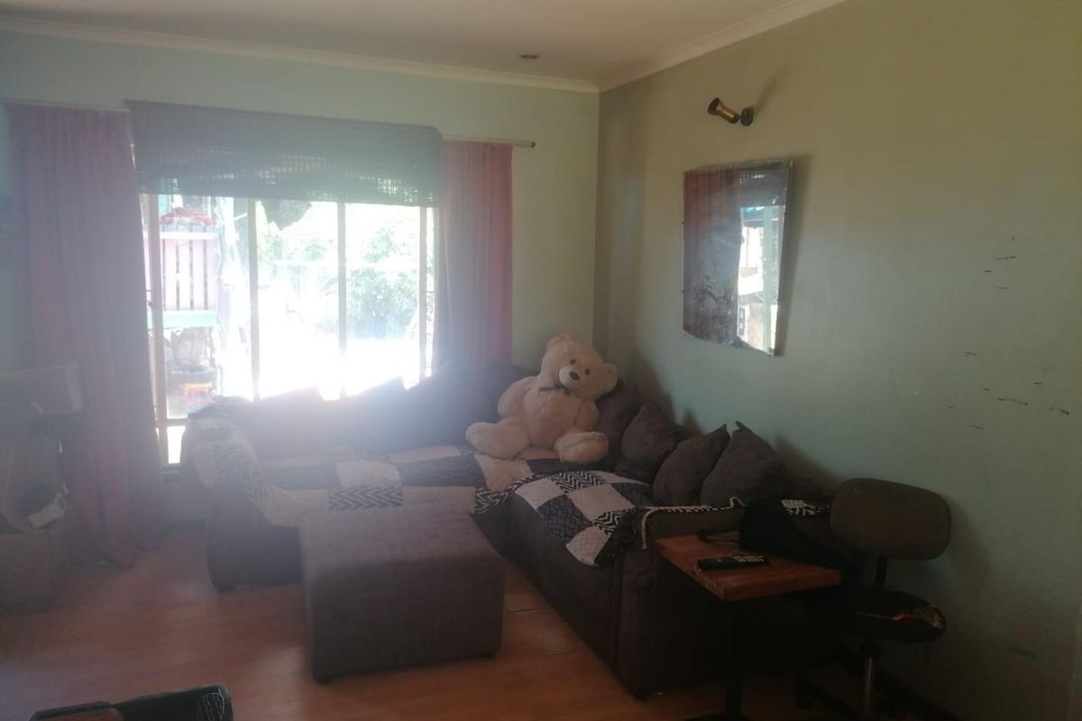 A living room featuring laminate flooring, recessed lighting, and a large sliding glass door providing access to the exterior.