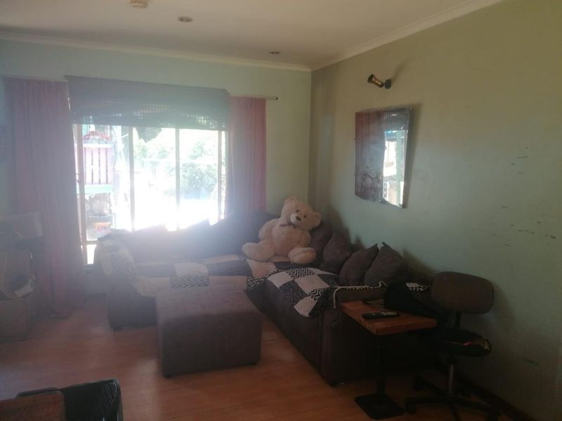 A living room featuring laminate flooring, recessed lighting, and a large sliding glass door providing access to the exterior.