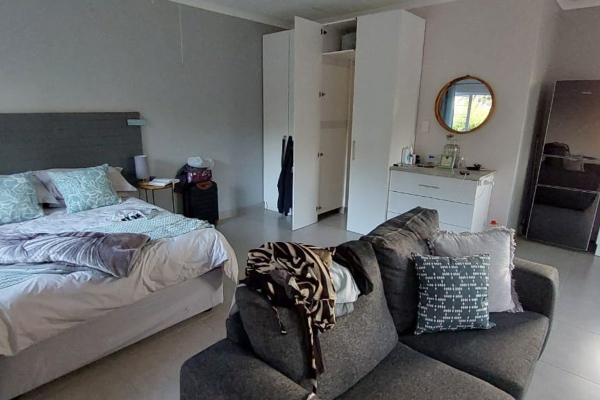Open-plan studio apartment featuring a combined bedroom and kitchen area with built-in cupboards and tiled flooring.