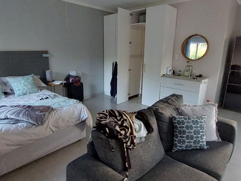 Open-plan studio apartment featuring a combined bedroom and kitchen area with built-in cupboards and tiled flooring.