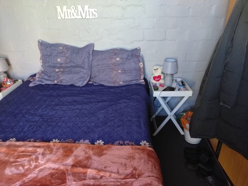 A bedroom featuring a painted brick feature wall, providing a textured backdrop for the sleeping area.