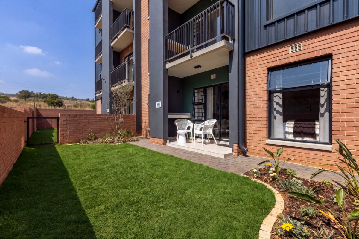 A well-maintained ground floor apartment featuring a private garden, paved patio area, and modern brick and metal exterior finishes.