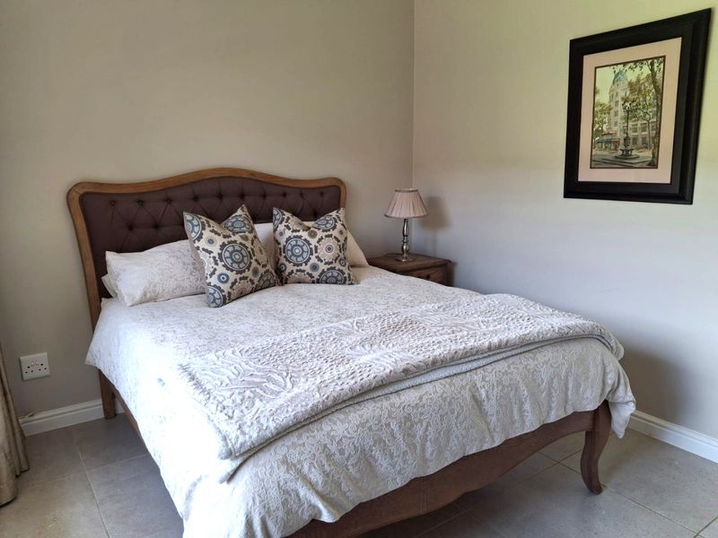 A well-maintained bedroom featuring neutral wall tones and tiled flooring, providing a clean and comfortable living space.