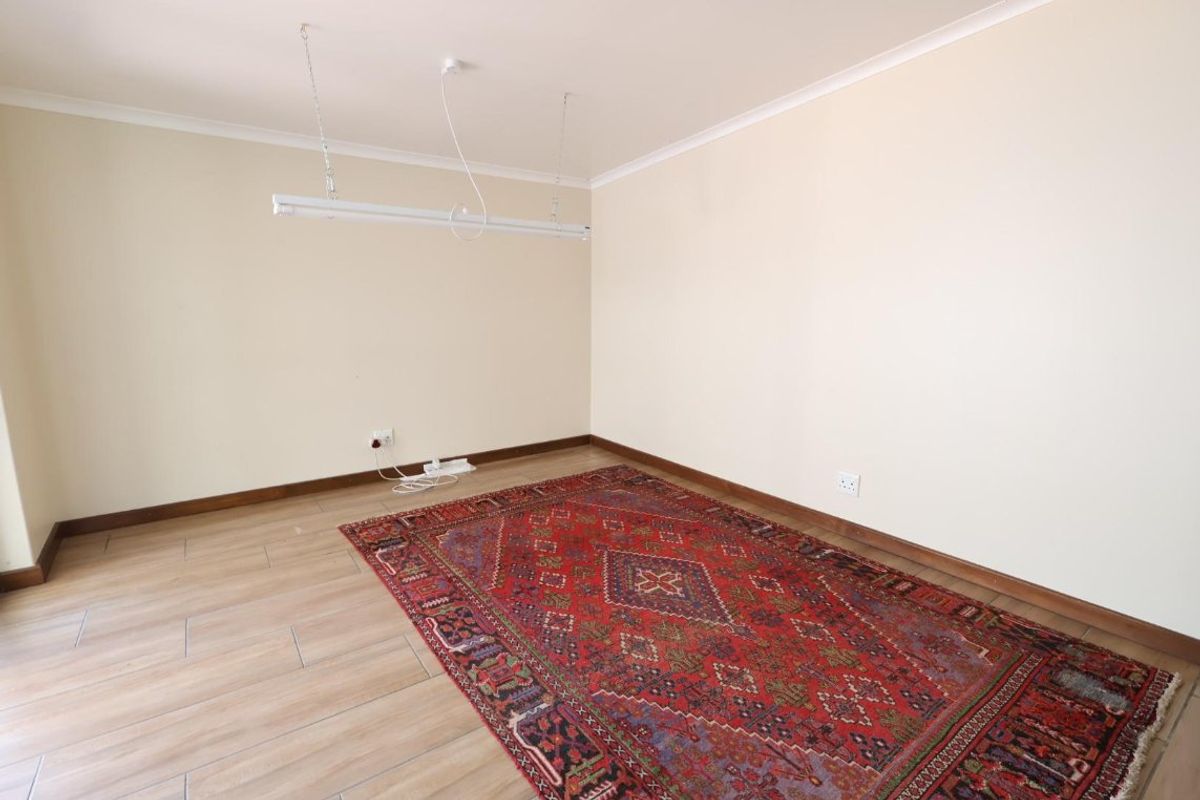 A bright, empty living area featuring neutral walls, tiled flooring, and coving, providing a versatile blank canvas for your interior design preferences.