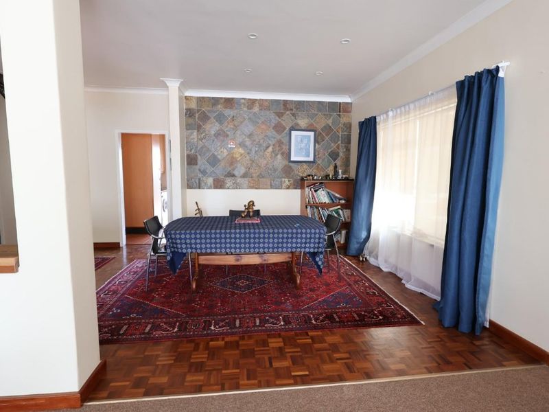 Dining room featuring classic parquet flooring and a decorative stone feature wall, providing a warm and traditional atmosphere.