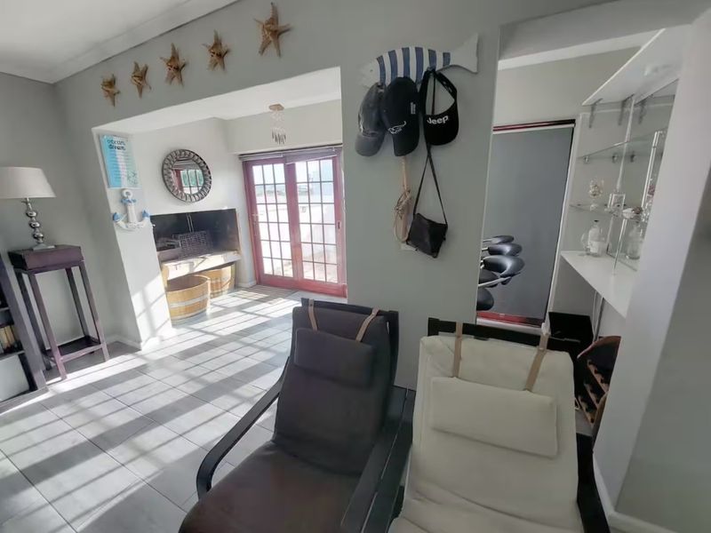 Living area featuring tiled flooring, a built-in fireplace, and glass french doors leading to an outdoor space.