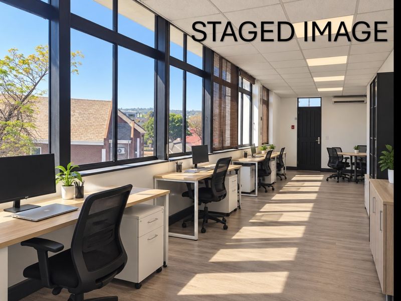 Modern commercial office space featuring large windows, suspended ceilings, recessed lighting, and air conditioning, providing a bright and professional work environment.