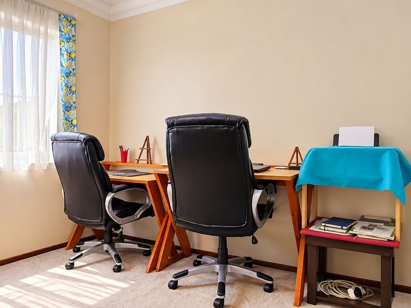 A functional home office space featuring neutral walls, carpeted flooring, and a built-in wardrobe, providing a practical area for work or study.
