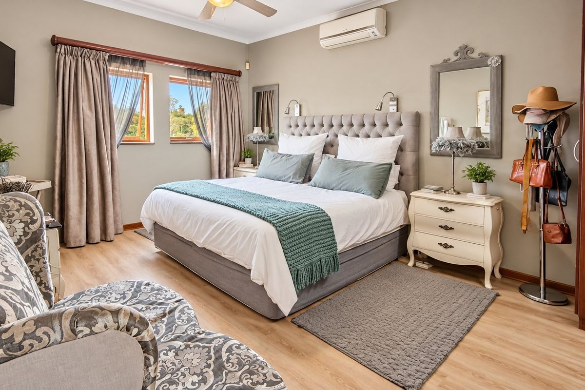 A well-maintained bedroom featuring laminate flooring, a ceiling fan, and a wall-mounted split-system air conditioner.
