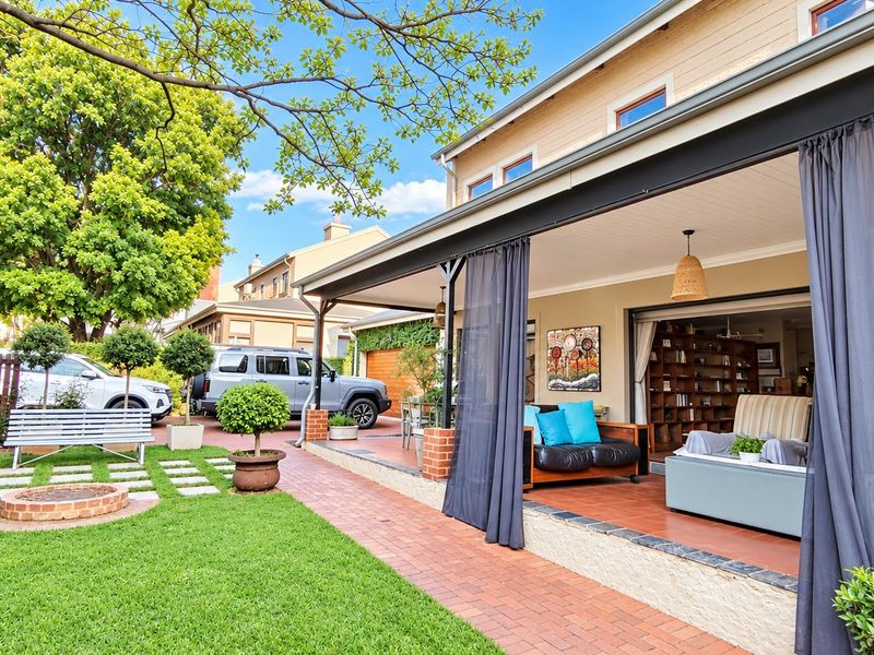 A spacious covered patio featuring brick paving and direct access to the garden, perfect for outdoor entertaining and seamless indoor-outdoor living.