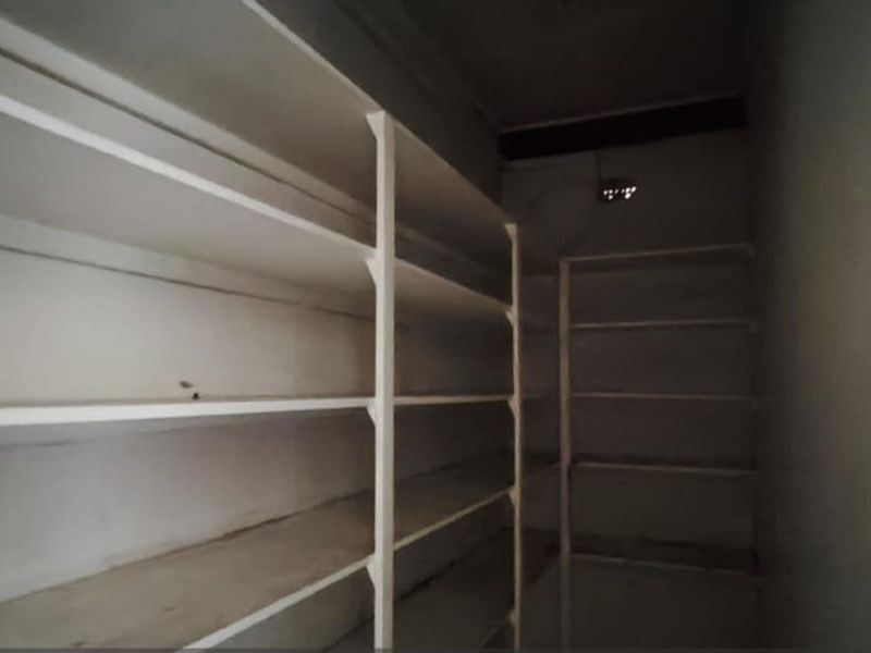 A utility storage area or pantry featuring extensive built-in shelving units, providing ample space for organization and storage.