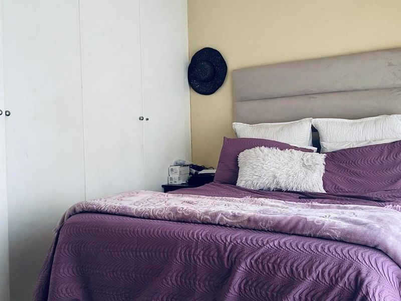 A bedroom featuring built-in cupboards and a neutral wall finish, providing a functional space for rest.