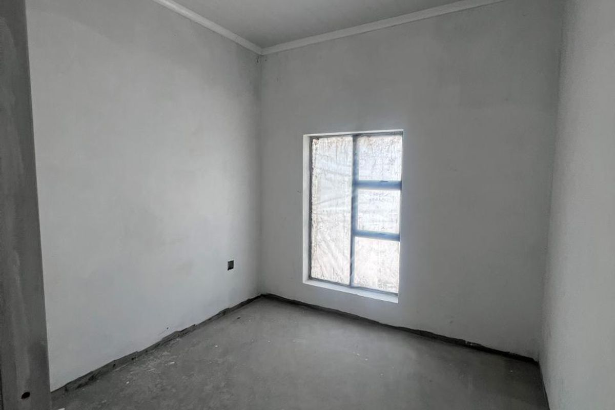 An unfinished bedroom space featuring concrete flooring, white walls, and a tongue and groove ceiling, ready for final flooring and paint finishes.