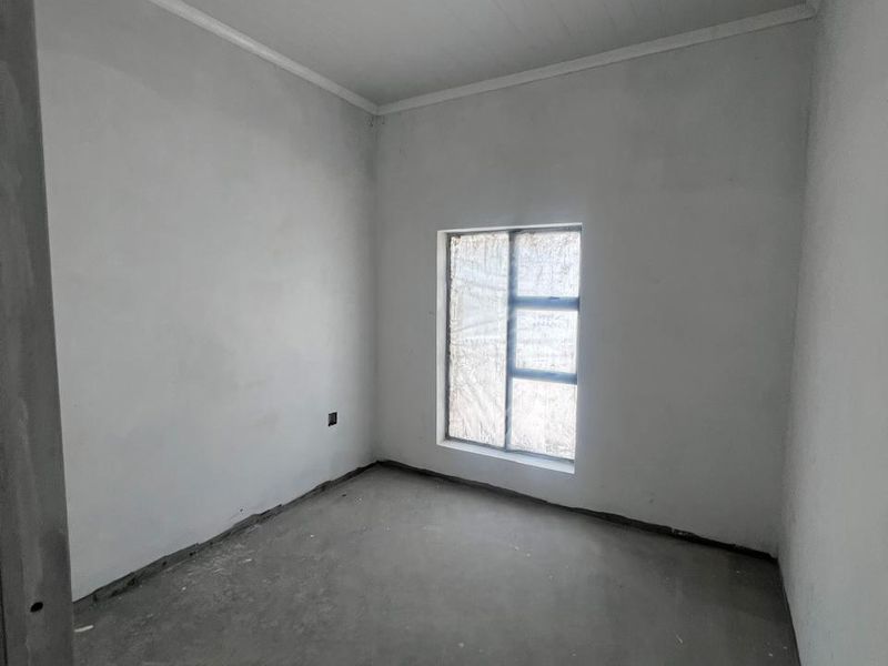 An unfinished bedroom space featuring concrete flooring, white walls, and a tongue and groove ceiling, ready for final flooring and paint finishes.