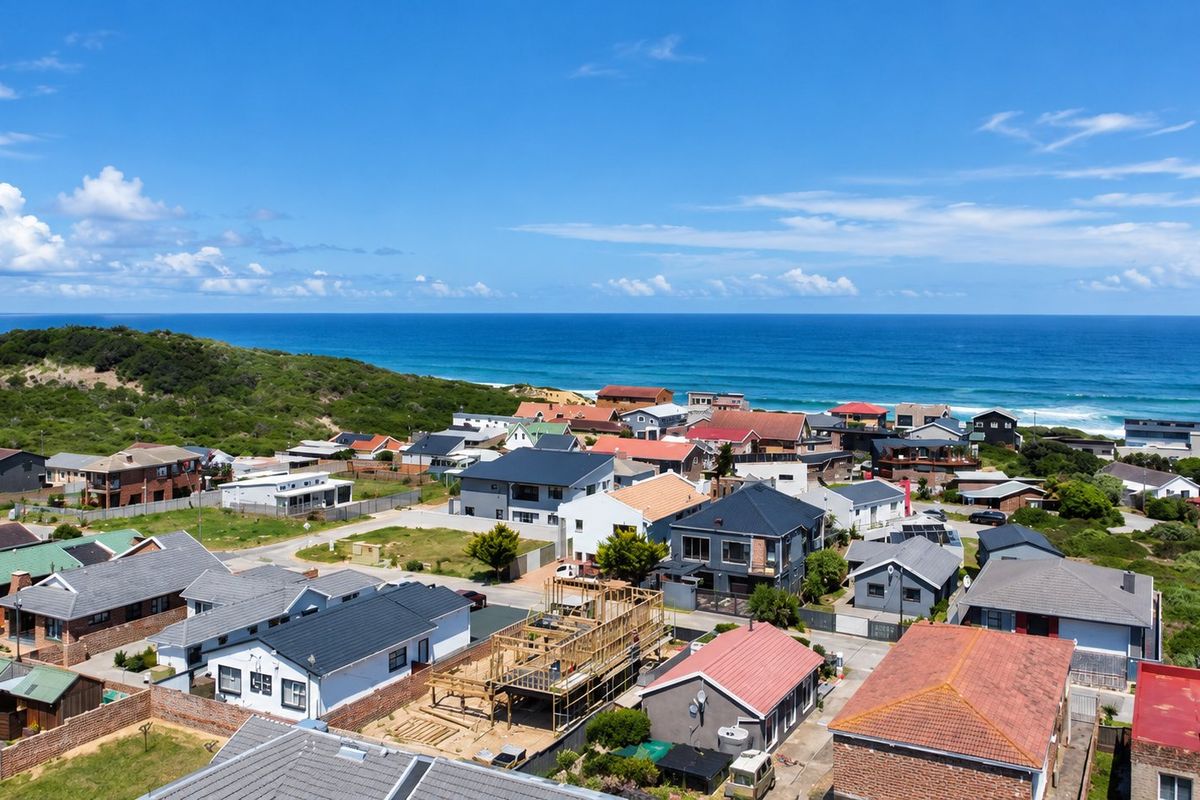 An aerial view of a coastal residential neighborhood featuring diverse housing styles and proximity to the ocean.