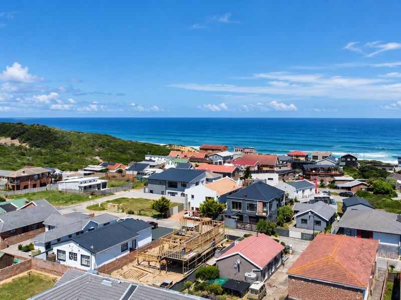 An aerial view of a coastal residential neighborhood featuring diverse housing styles and proximity to the ocean.
