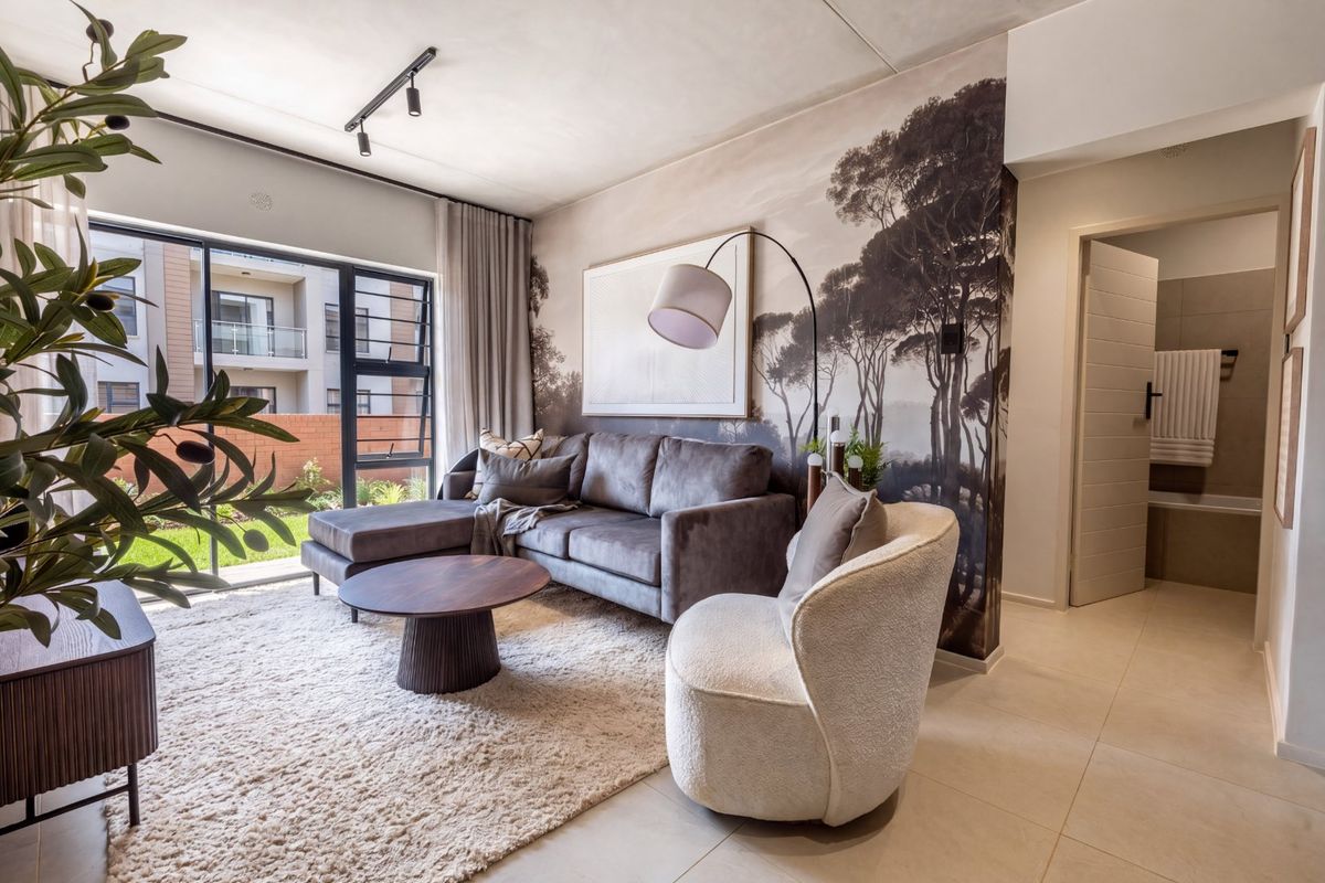 Modern living room featuring tiled flooring, track lighting, and a large sliding glass door providing natural light and access to the exterior.