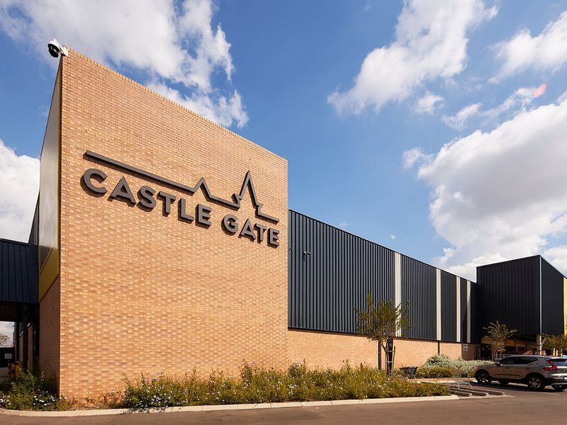 Exterior view of the Castle Gate commercial building featuring a modern brick and metal facade with integrated security infrastructure.
