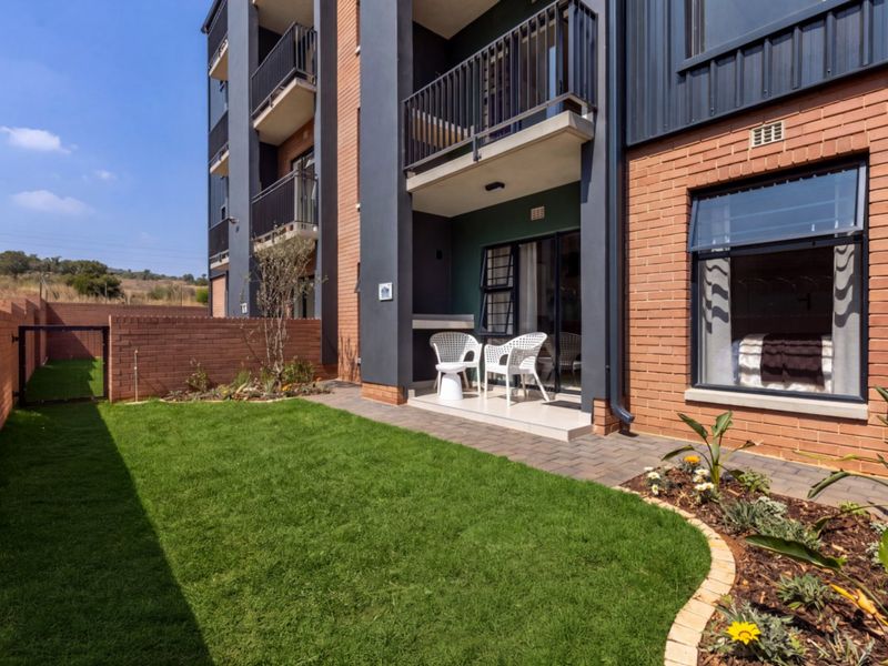 A well-maintained ground floor apartment featuring a private garden, paved patio area, and modern brick and metal exterior finishes.