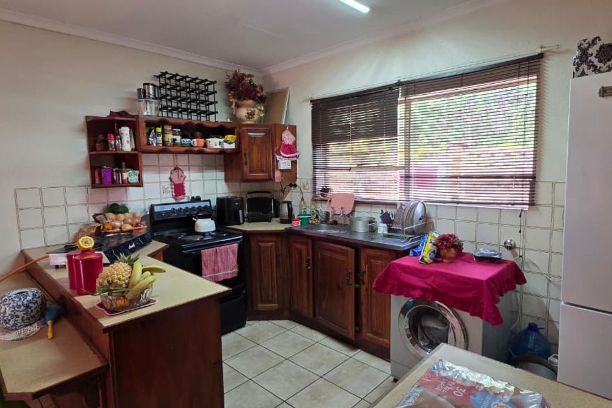 A functional kitchen featuring wooden cabinetry, tiled backsplash, and built-in stove, offering a practical layout with potential for modern cosmetic updates.