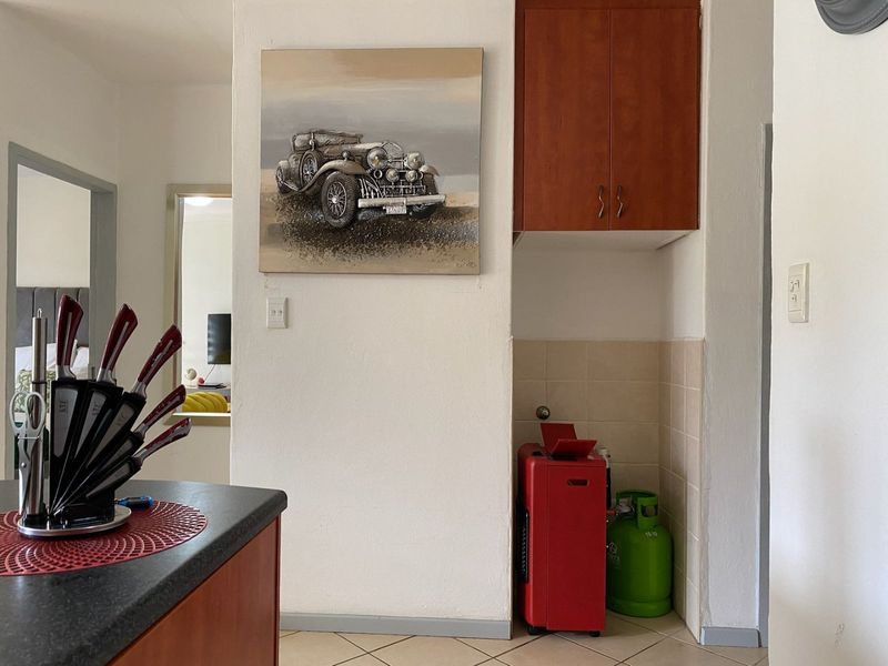 A kitchen area featuring built-in cabinetry and a tiled splashback, providing functional storage and workspace within the apartment.