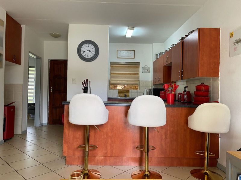 A functional kitchen featuring laminate cabinetry, a breakfast bar, and tiled flooring, offering a practical layout for daily meal preparation.