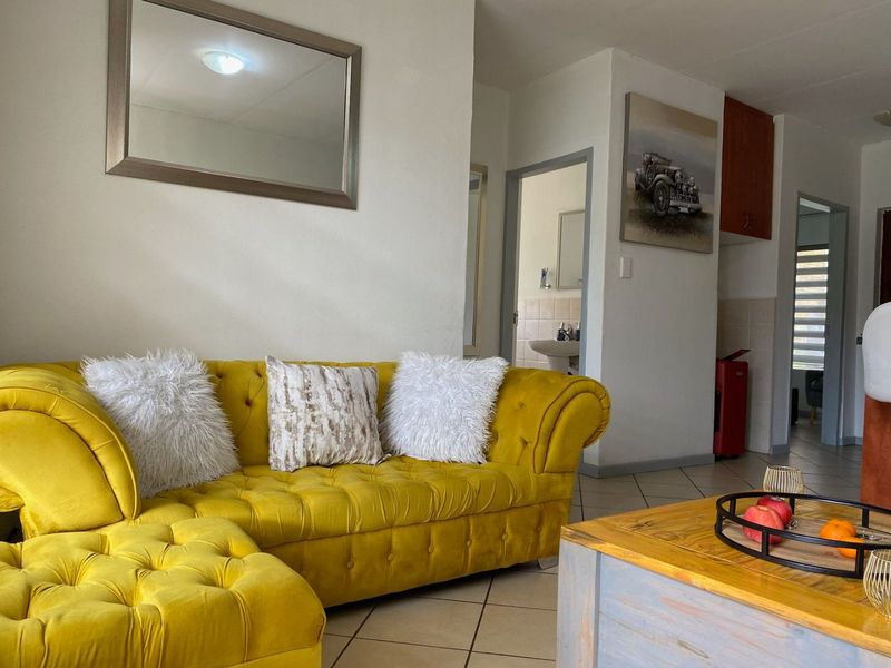 Open plan living area featuring tiled flooring and access to adjacent rooms, providing a functional layout for apartment living.