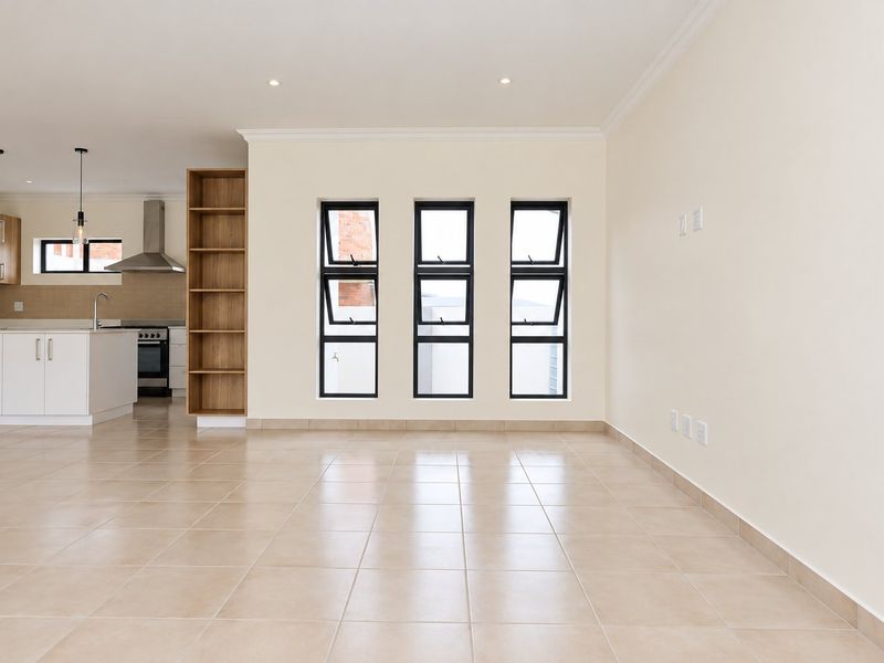 Spacious open-plan living area featuring tiled floors, recessed lighting, and a modern kitchen with built-in cabinetry, oven, and extractor fan.
