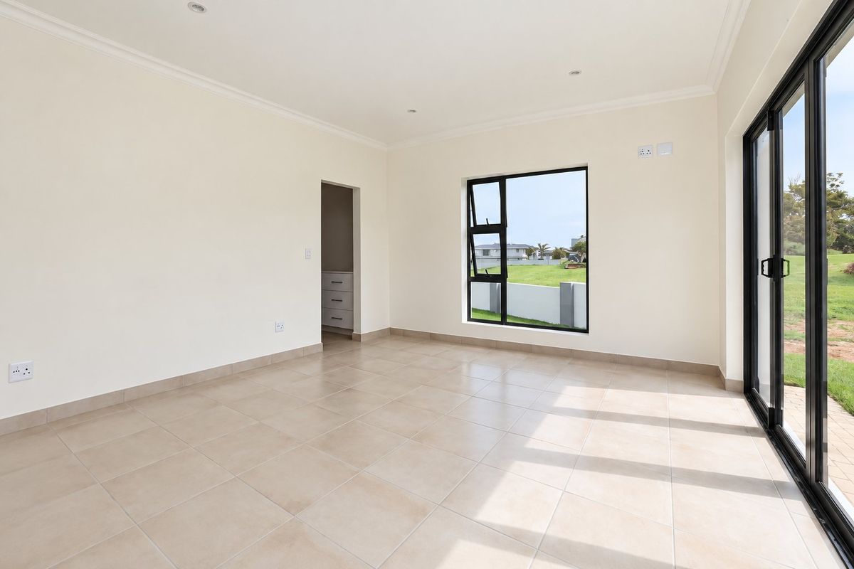 A bright, modern, and empty living area featuring neutral tiled floors, large aluminium sliding doors, and clean finishes, ready for personalization.
