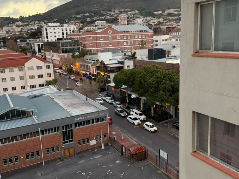 Elevated urban view overlooking the street, surrounding buildings, and Lion's Head mountain in the distance.