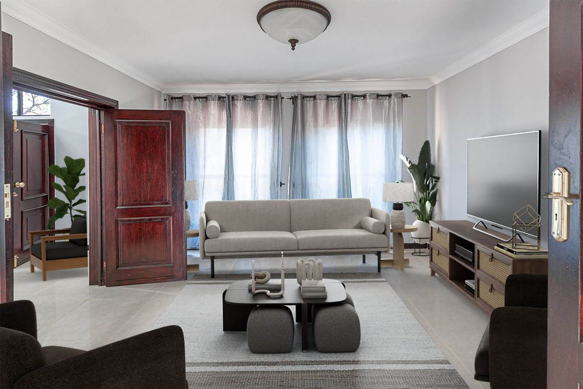 A well-maintained living room featuring tiled flooring, crown molding, and solid wood doors, offering a bright and comfortable space for relaxation.