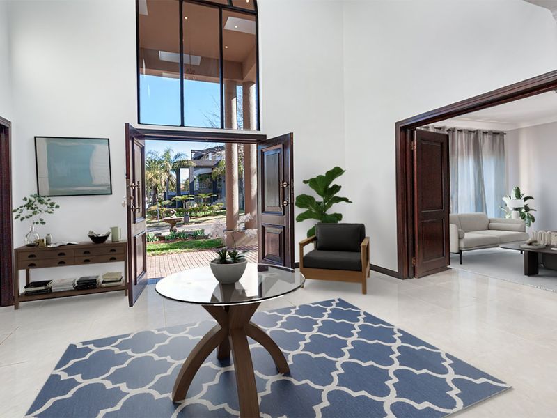 Spacious double-volume entrance hall featuring high ceilings, large transom windows, and tiled flooring, providing a bright and welcoming transition into the home.