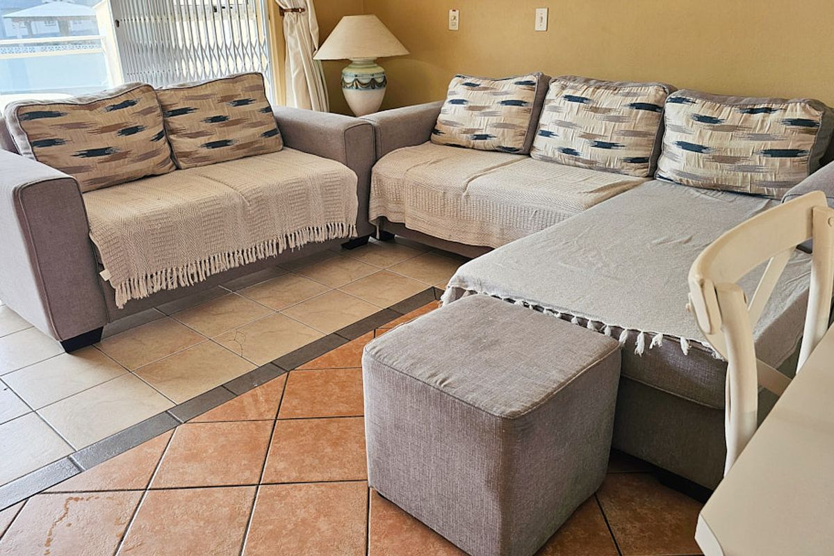 A living area featuring ceramic floor tiles and a sliding glass door providing access to an outdoor space.
