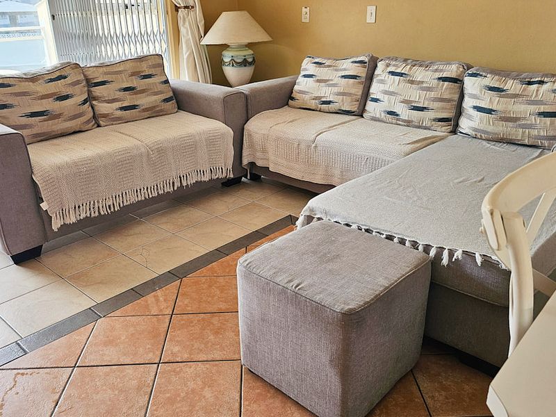 A living area featuring ceramic floor tiles and a sliding glass door providing access to an outdoor space.
