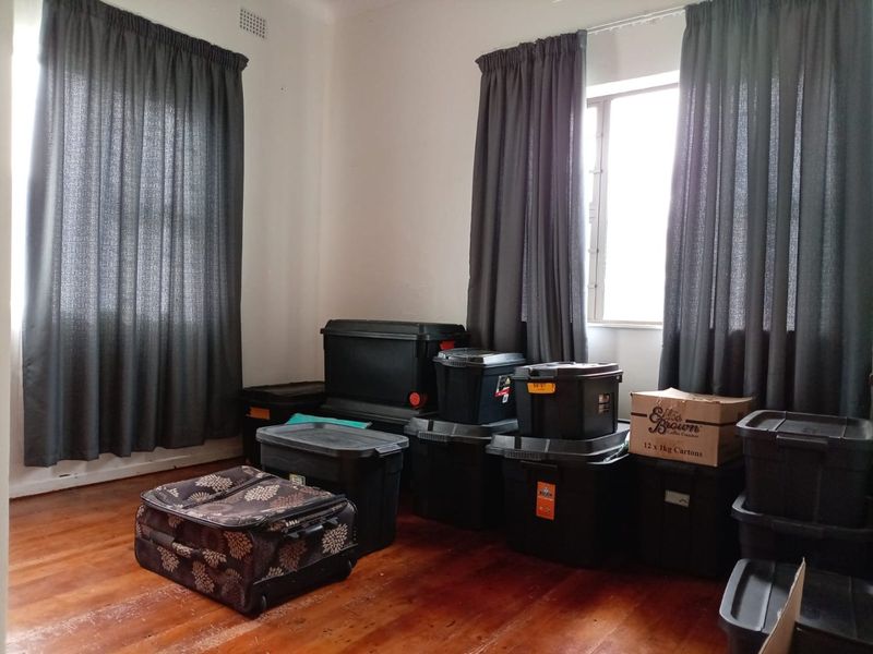 A vacant bedroom featuring timber flooring and dual windows with curtain tracks, offering a blank canvas for potential interior design updates.